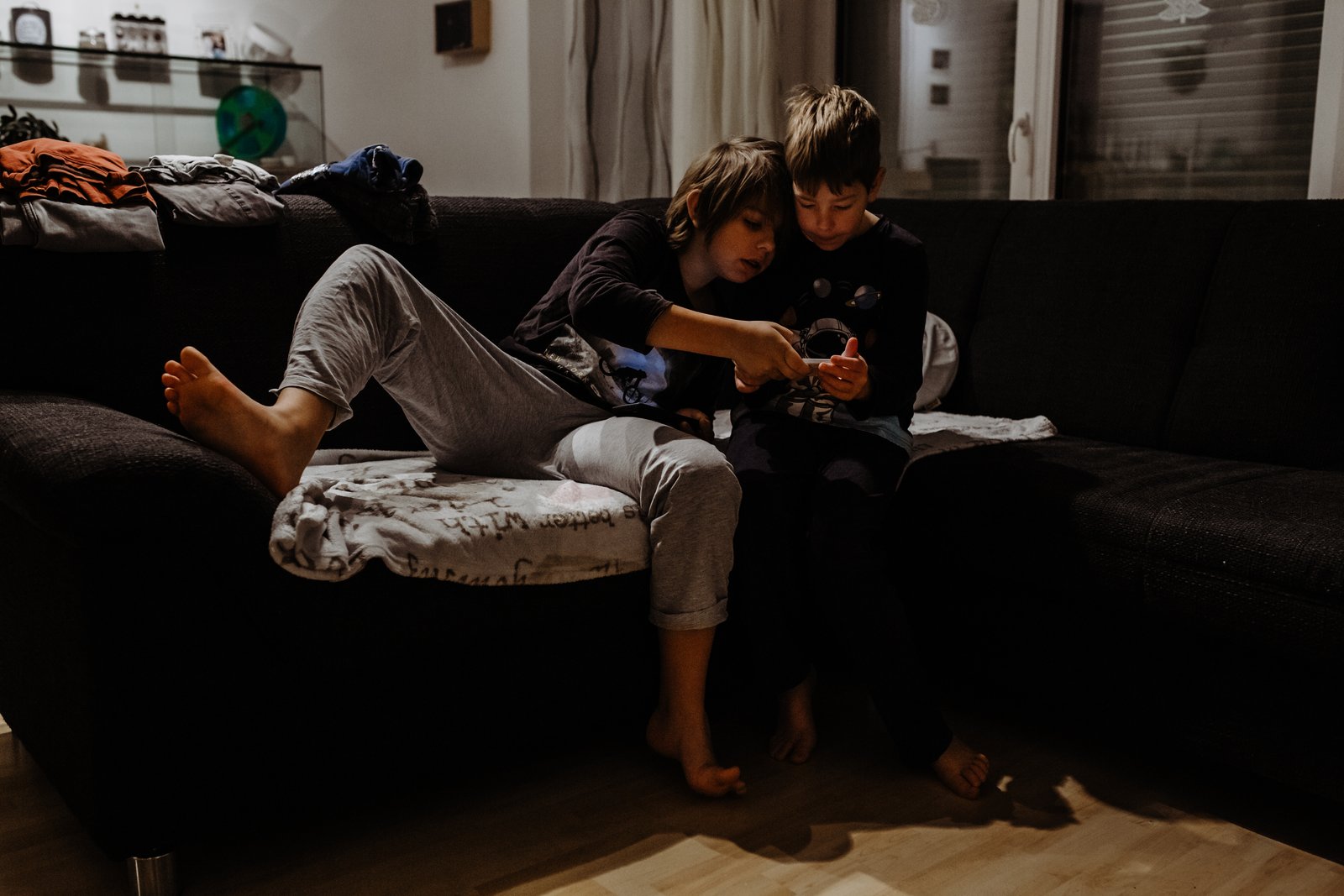 Vater und Kinder sitzen am Morgen gemeinsam auf dem Sofa.