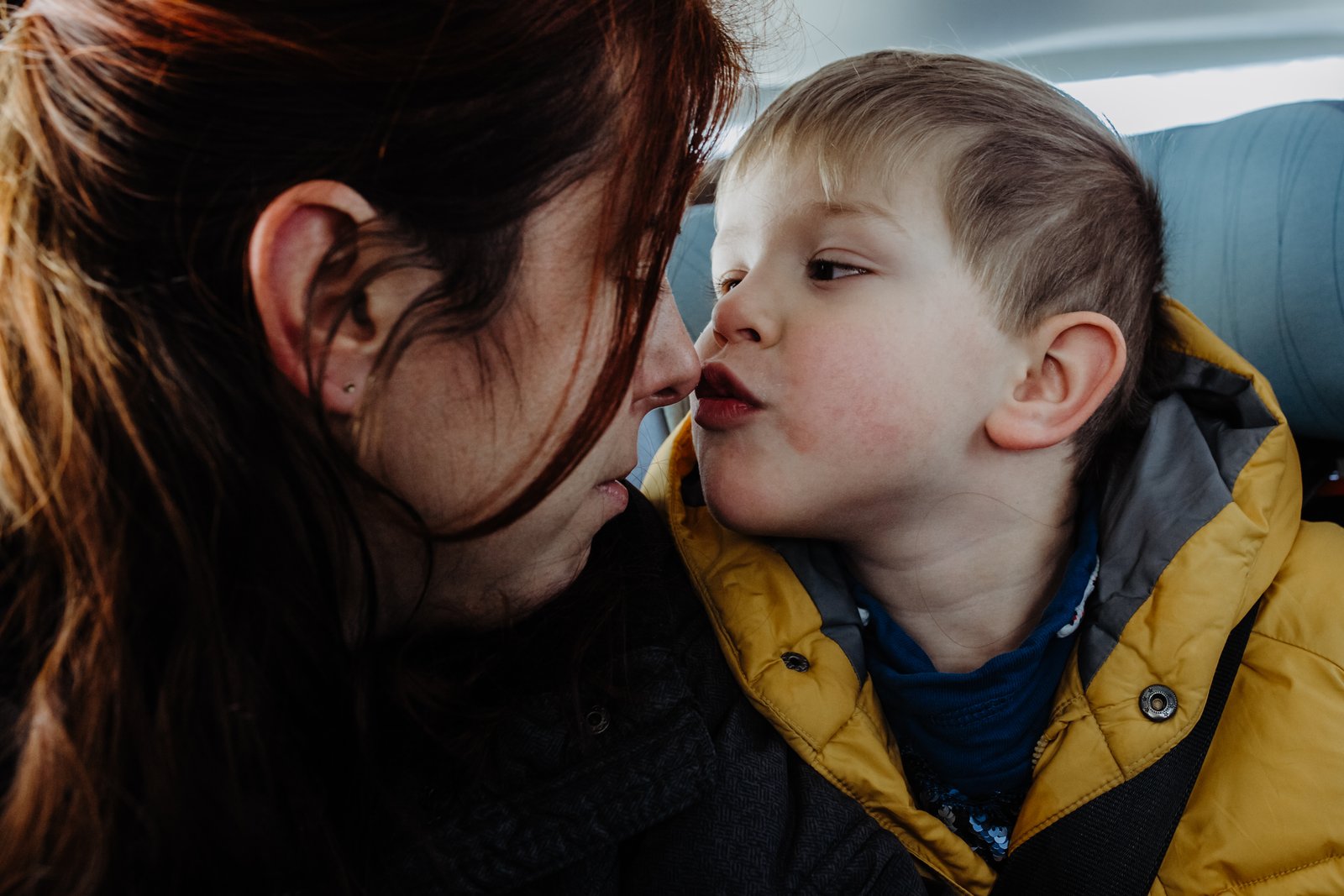 Eine Mutter und ihr kleiner Sohn berühren sich mit den Gesichtern.