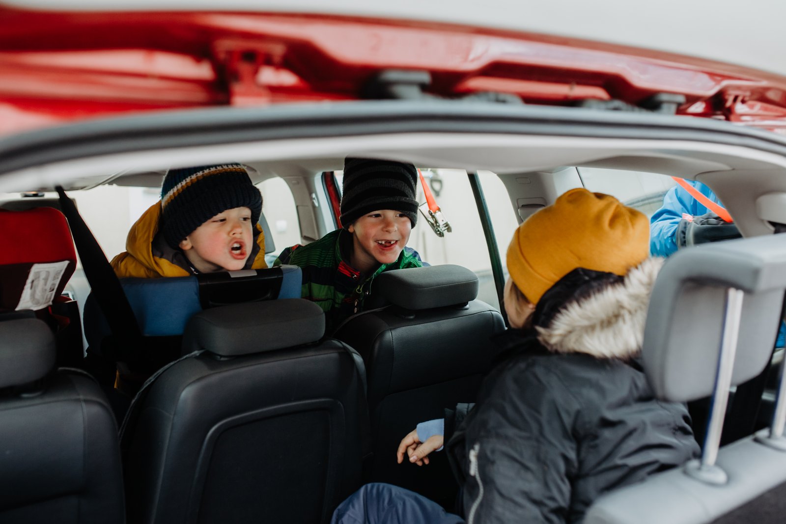 Zwei Brüder begegnen sich zwischen den Sitzen im Auto.